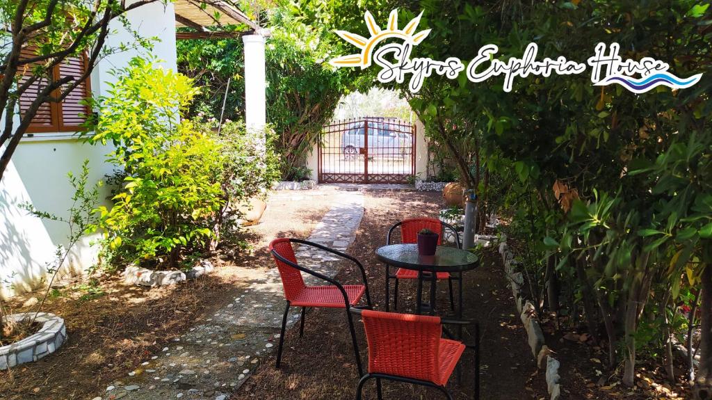 stół i cztery krzesła w ogrodzie w obiekcie Skyros Euphoria House w mieście Skiros