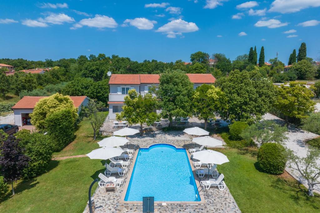 an aerial view of a swimming pool with umbrellas and a resort at Apartments Grota in Poreč