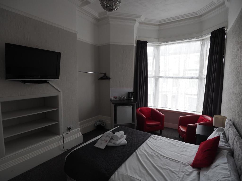 a hotel room with a bed and a television at Richmond House in Southport
