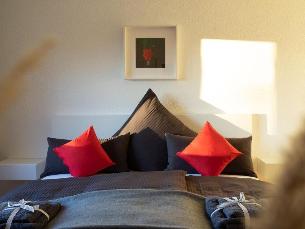 um quarto com uma cama com almofadas vermelhas em Ferien am Weinberg em Kappelrodeck