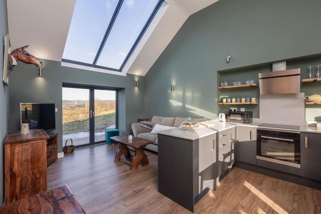 a kitchen and living room with a vaulted ceiling at Green End Farm Cottages The Stables in Goathland