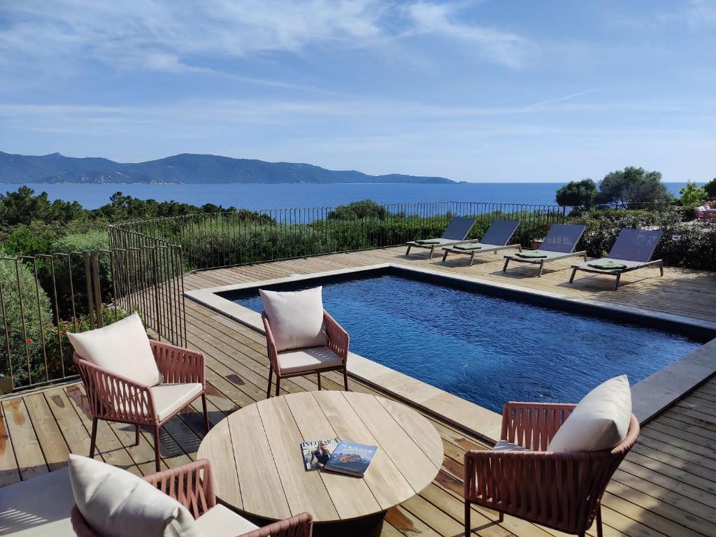 una terraza con sillas, piscina, mesa y sillas en Résidence La Plage, en Propriano