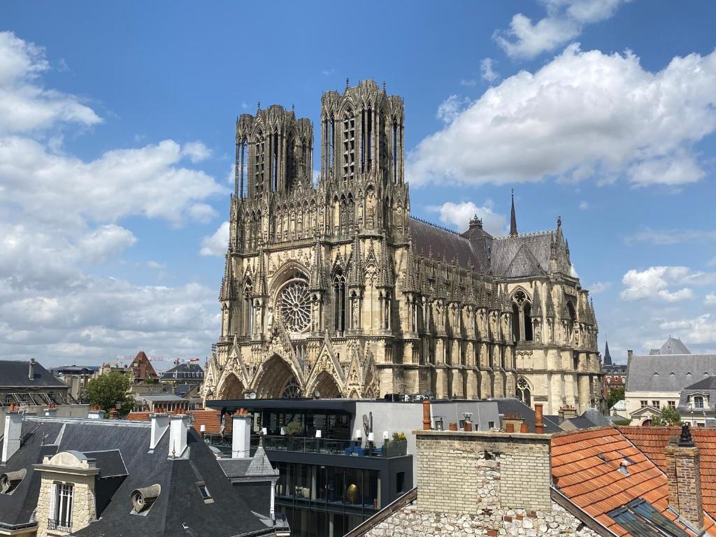 una gran catedral con una torre de reloj en una ciudad en Duplex hammam au pied de la Cathédrale avec vue en Reims