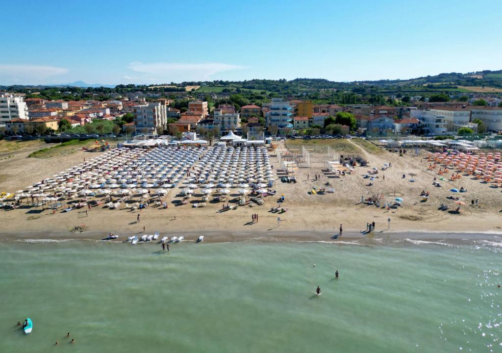 a beach with a lot of umbrellas and people on it at Hotel Sayonara in Senigallia