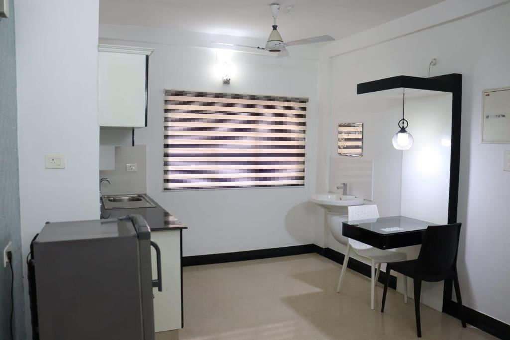a kitchen with a table and a sink and a window at Uthradam towers in Trivandrum