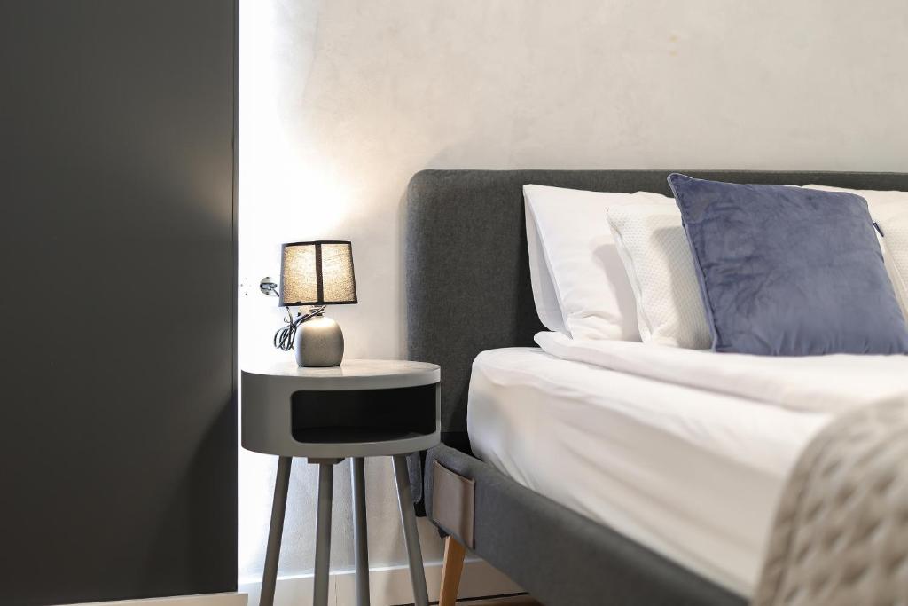 a bed with a side table with a lamp on it at Residence INN Rijeka in Rijeka