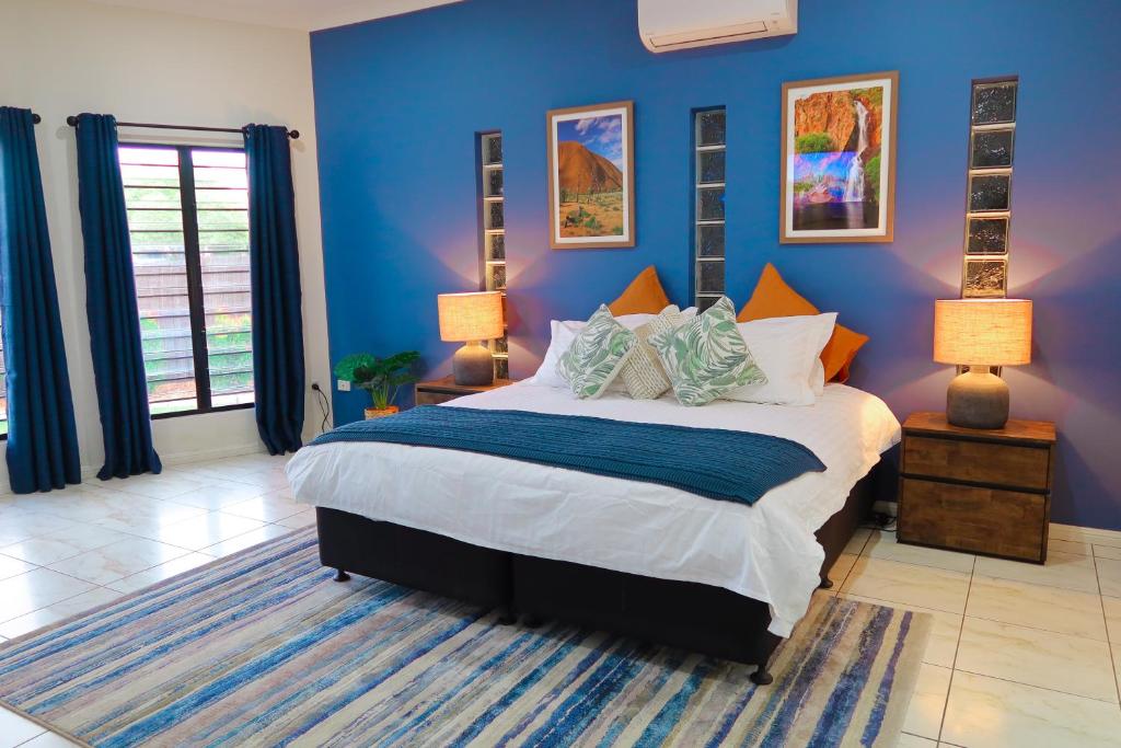 a bedroom with a large bed with blue walls at Top End Getaway - Luxury Home in Palmerston