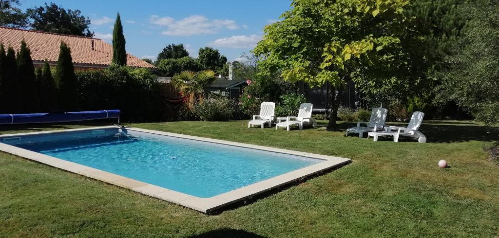 einen Pool im Hof mit zwei Gartenstühlen und einer Gruppe in der Unterkunft Maison contemporaine à Artigues-près-Bordeaux in Artigues-près-Bordeaux