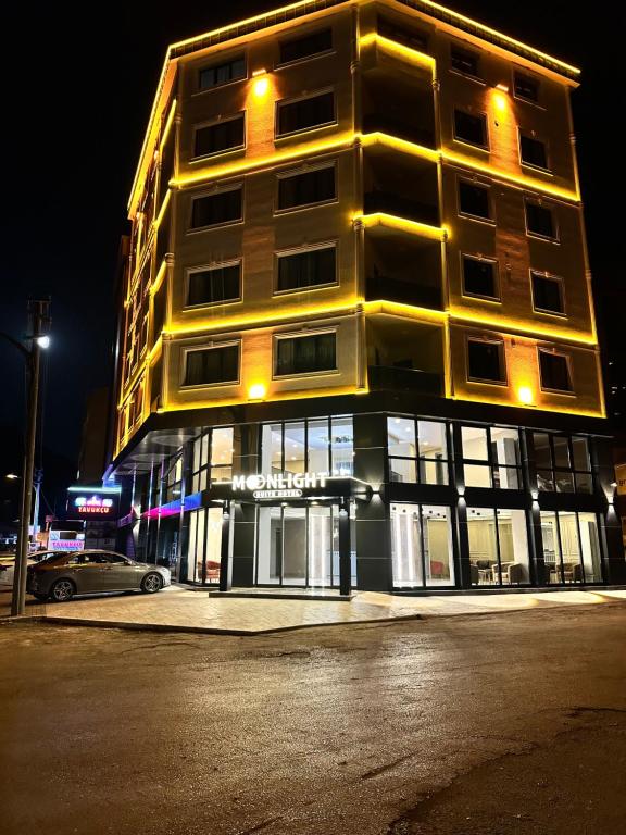 un edificio alto en una calle de la ciudad por la noche en Moonlight Suite Hotel, en Trabzon