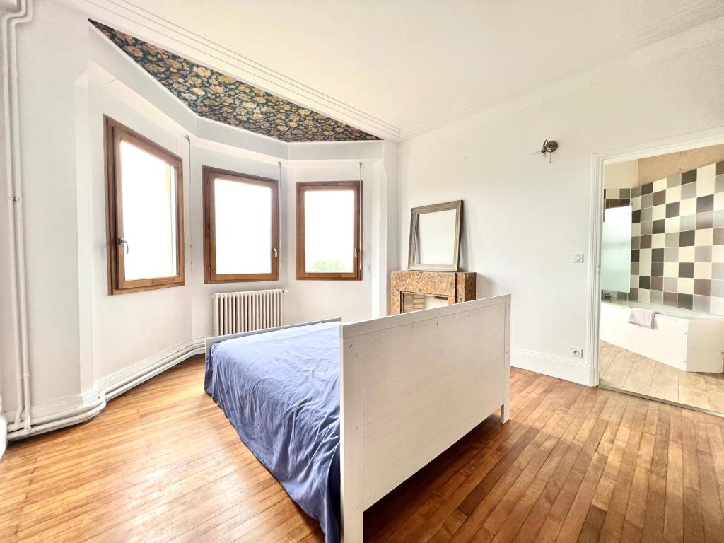 a white bedroom with a bed and a bathroom at Les hauts de tison ~ Vue sur la vallée du Clain in Poitiers