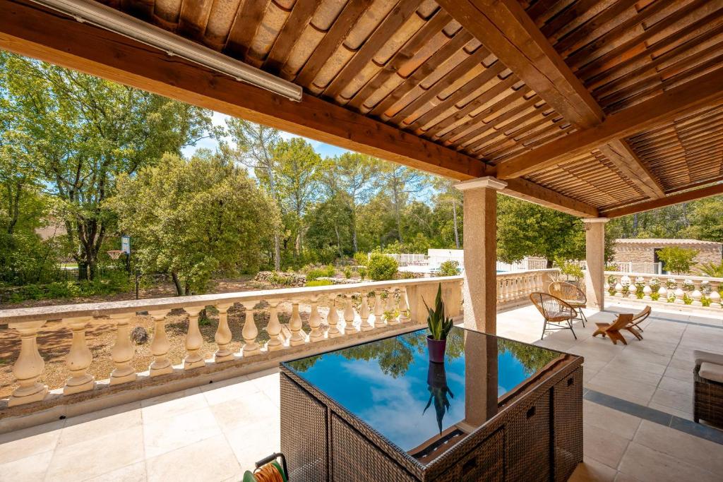 un patio al aire libre con piscina y pérgola de madera en Ma Case en Provence - Maison climatisée avec piscine, en Saint-Maximin-la-Sainte-Baume