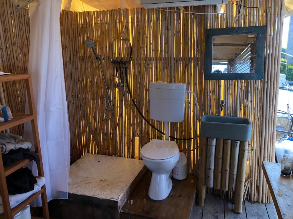 a bathroom with a toilet in a bamboo wall at קמפינג על הגג ביפו in Tel Aviv