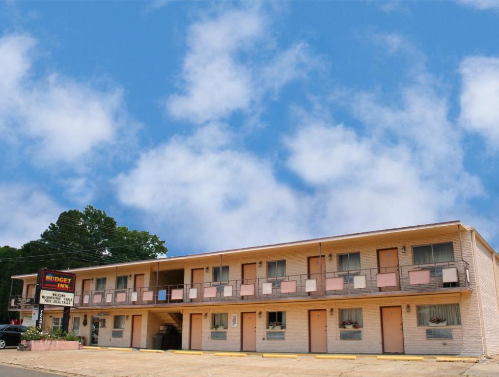 un edificio alberghiero con un cielo nuvoloso sullo sfondo di Budget Inn Jonesboro a Jonesboro