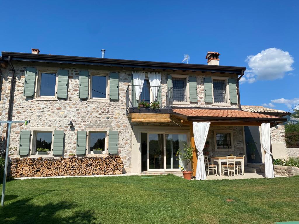 a large stone house with a balcony and lawn at B&B Casa Trambasore in Caprino Veronese