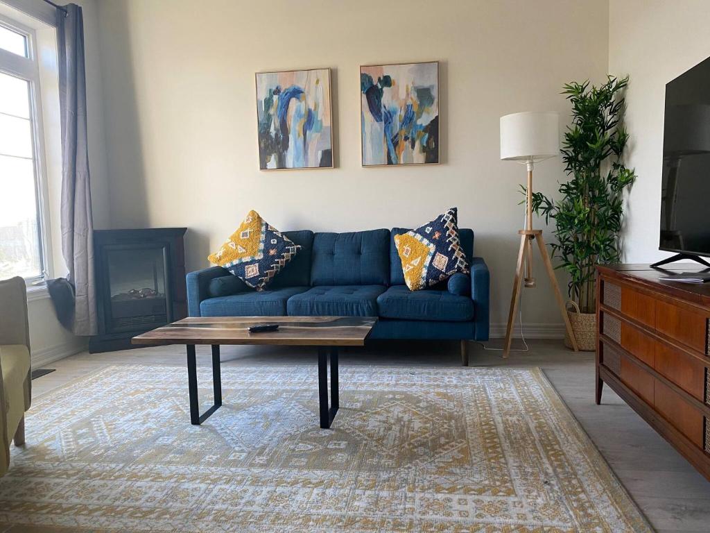 a living room with a blue couch and a coffee table at Luxurious town house with x2 Cars Garage no01 in Cambridge