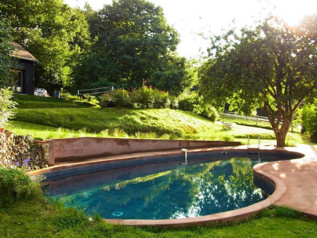 einen Pool in einem Garten mit Gartenanlagen in der Unterkunft Maison, Piscine, proche Deauville in Saint-Pierre-de-Cormeilles