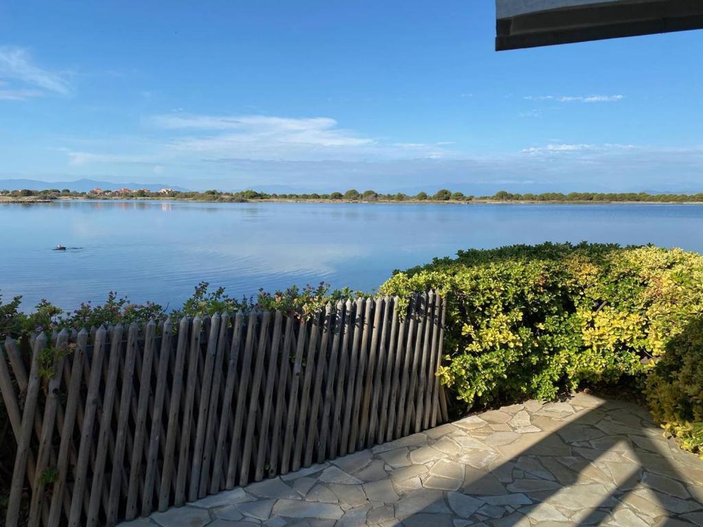 une clôture en bois à côté d'une masse d'eau dans l'établissement Pavillon T3 Mezzanine, 5 personnes, Terrasse, Parking - FR-1-81-68, à Port-Leucate