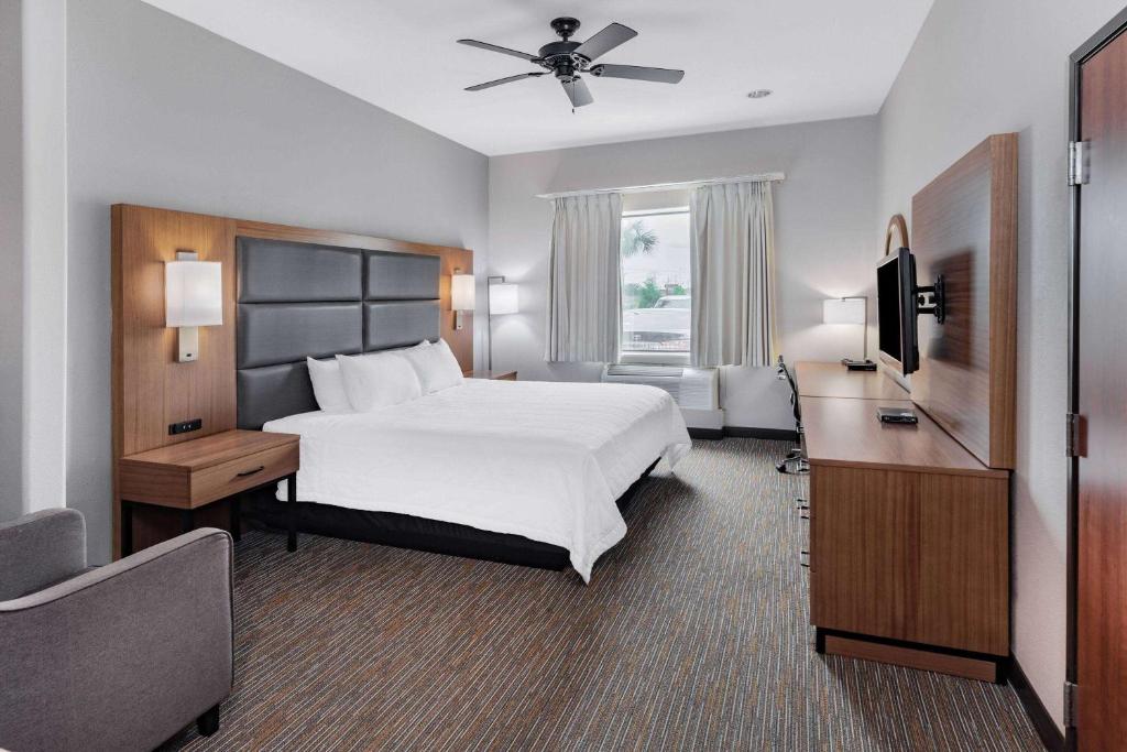 a hotel room with a bed and a flat screen tv at Wingate by Wyndham Houston Bush Intercontinental Airport in Houston