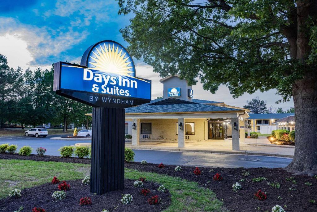 a days inn and suites sign in front of a building at Days Inn & Suites by Wyndham Colonial in Williamsburg