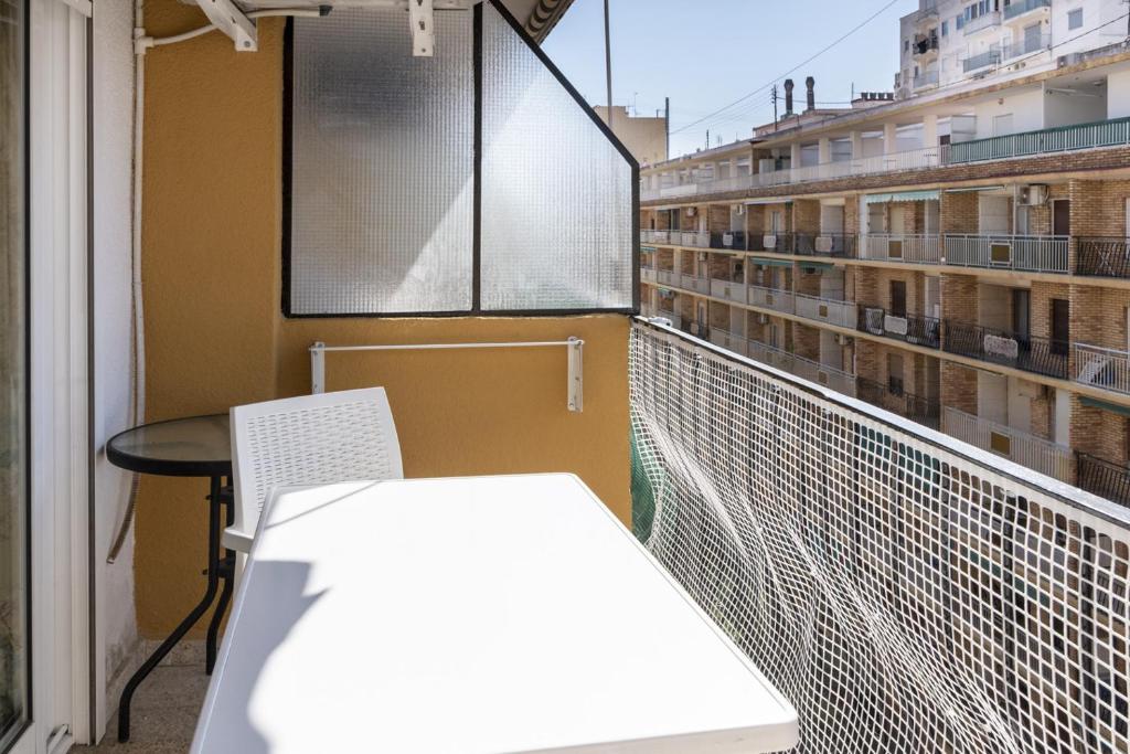 a balcony with a table and chairs on a building at Mar Y Montaña 7º-119 in Cullera