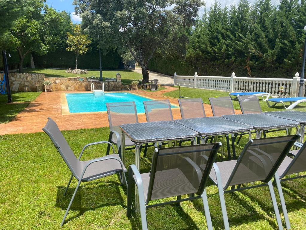 a table and chairs in a yard with a pool at El Magnoliio in Santa Cruz de Pinares