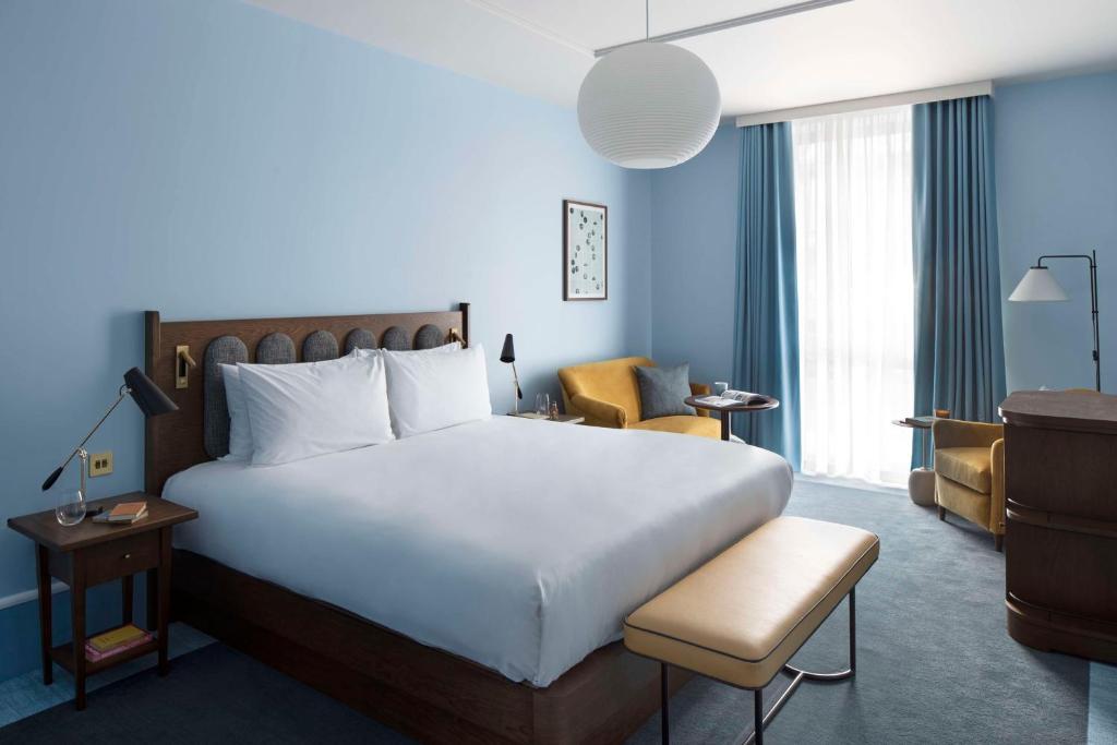 una habitación de hotel con una cama grande y una silla en Hyatt Centric Cambridge en Cambridge