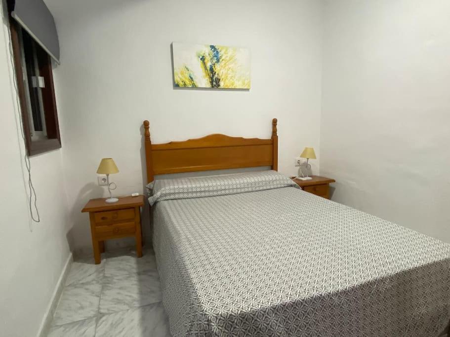 a bedroom with a bed and two nightstands and two lamps at Cozy Apartment in Chiclana City Center by Chiclana Dreams in Chiclana de la Frontera