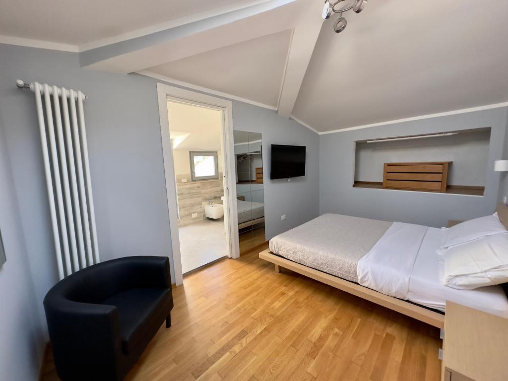 1 dormitorio con 1 cama y 1 silla negra en Sweet Home Desiree, en Florencia