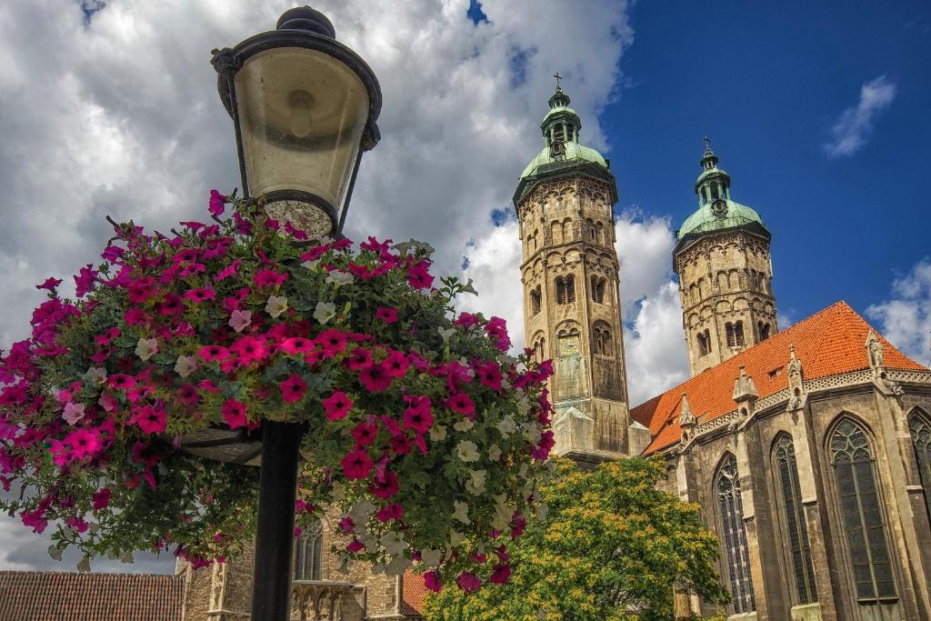 a street light with a basket of flowers in front of a church at Ferienwohnung Saaletal in Naumburg