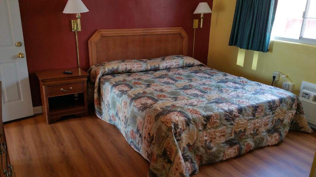 A bed or beds in a room at Slumber Motel