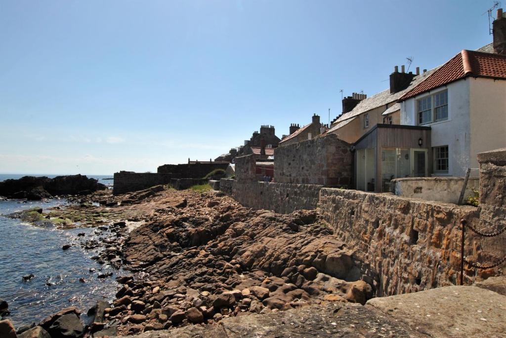 a group of houses on the rocks near the water at Aqua Vista- seafront cottage Cellardyke in Anstruther