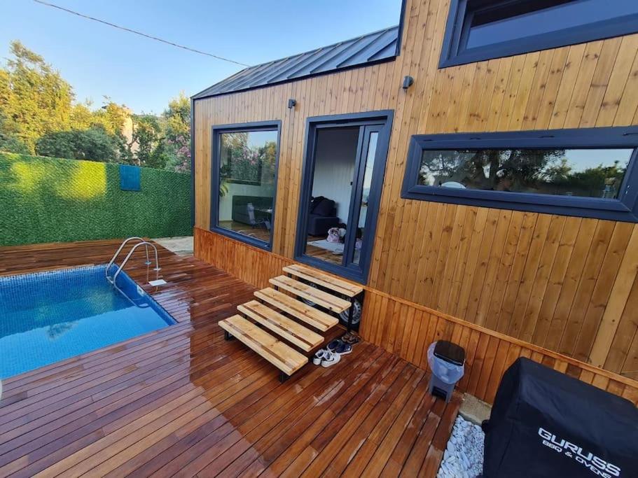 a house with a wooden deck and a swimming pool at Antik Tiny House in İznik