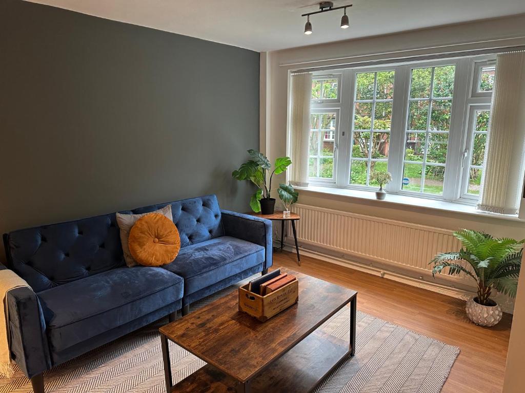 een woonkamer met een blauwe bank en een tafel bij Comfortable 3 Bed House with Garden & Parking in Nottingham