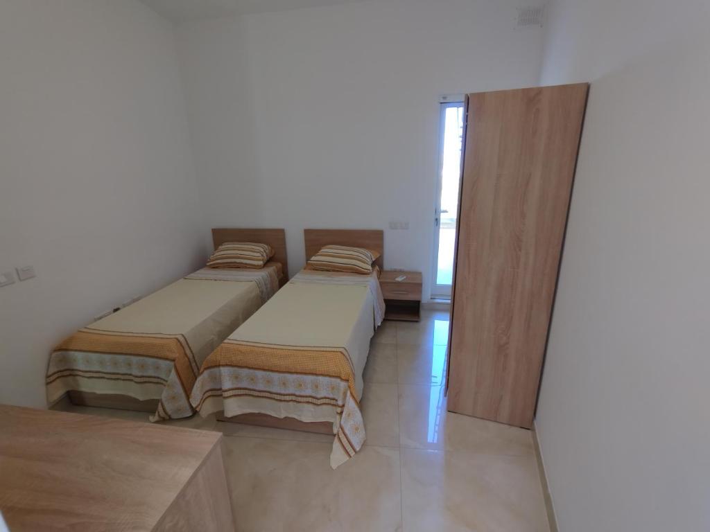 a bedroom with two beds and a sliding glass door at The Luxury Home - Next to airport! in Kirkop