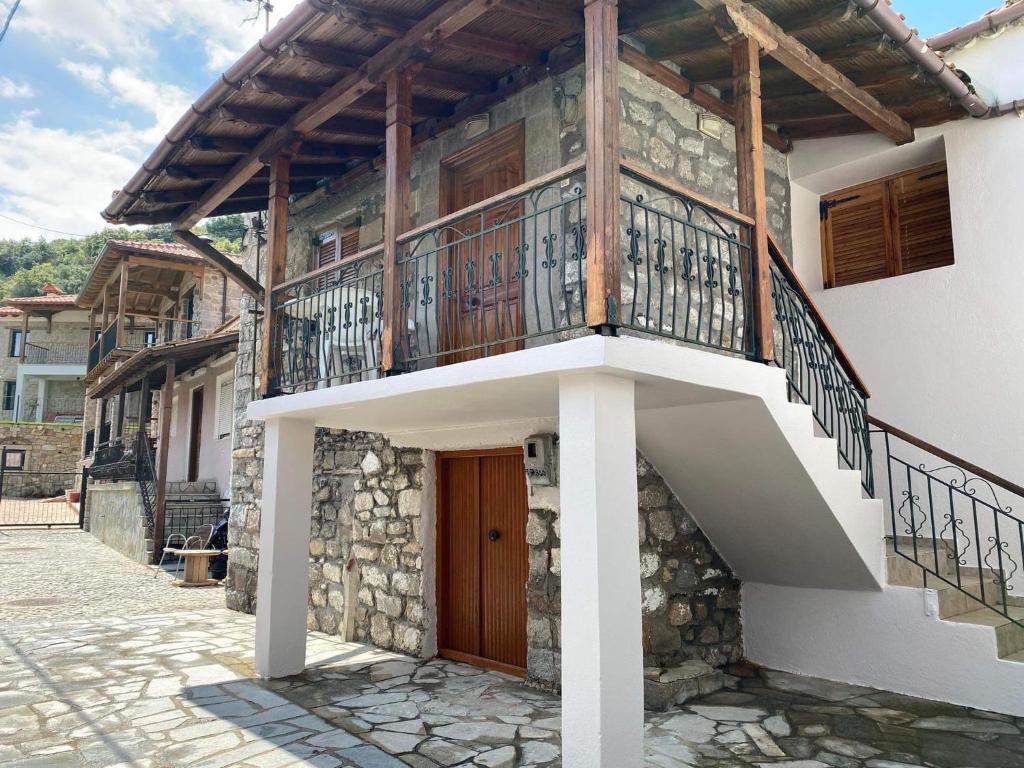 a house with a balcony and a staircase at Despina’s House in Sykia Chalkidikis