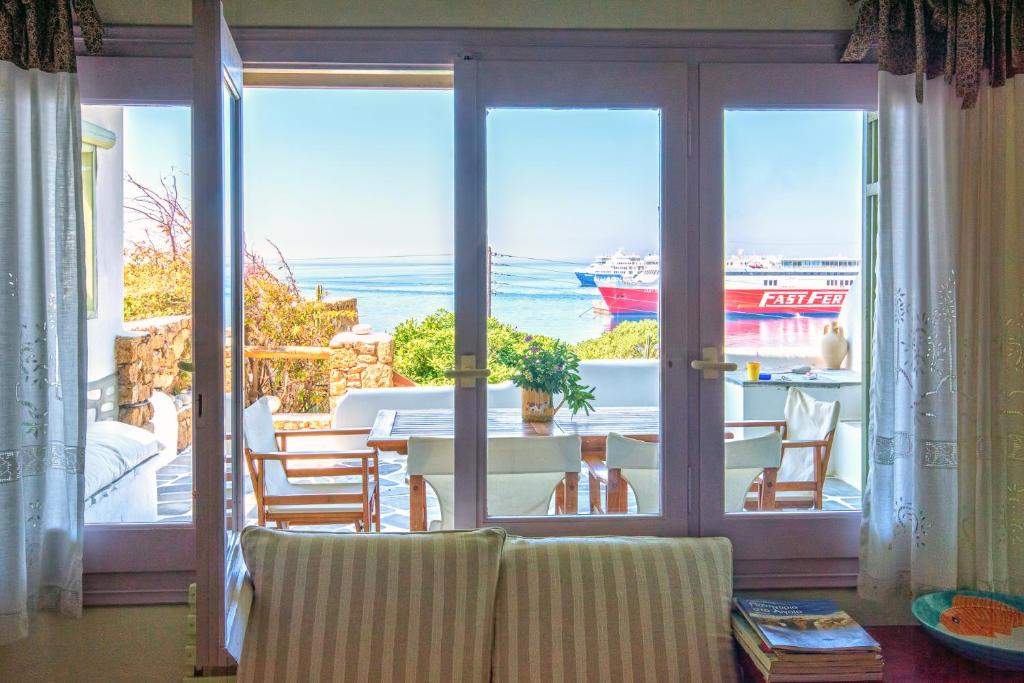 Tourlos Beachfront House in Mykonos في تورلوس: غرفة معيشة مطلة على المحيط
