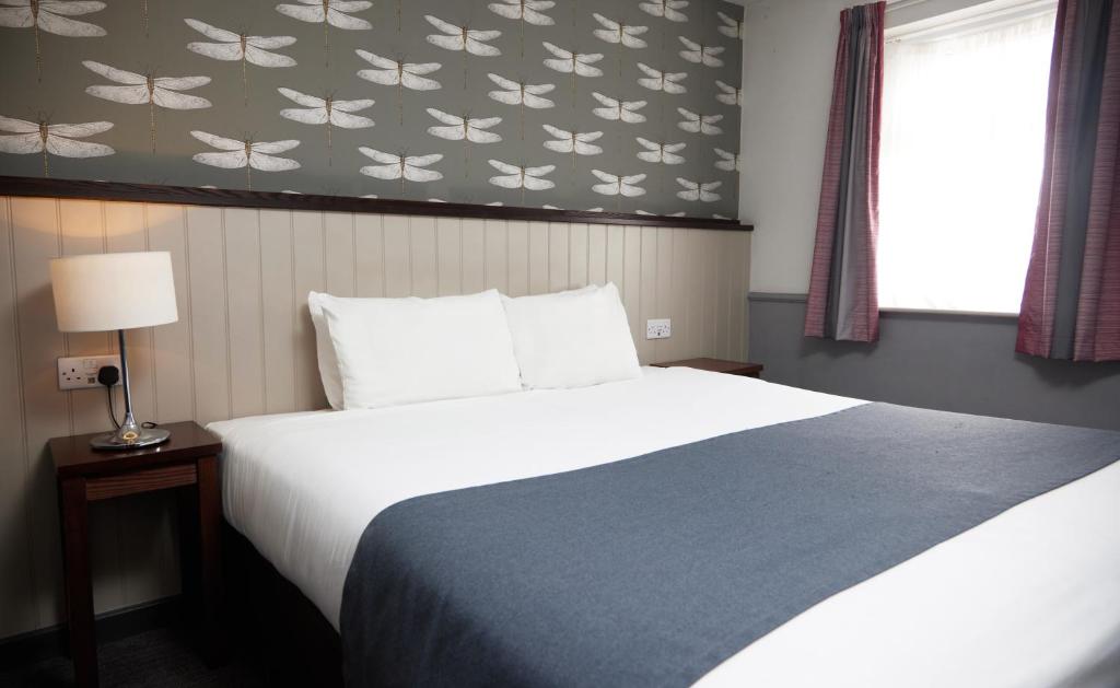 um quarto com uma cama grande e uma janela em Charnwood Arms em Coalville