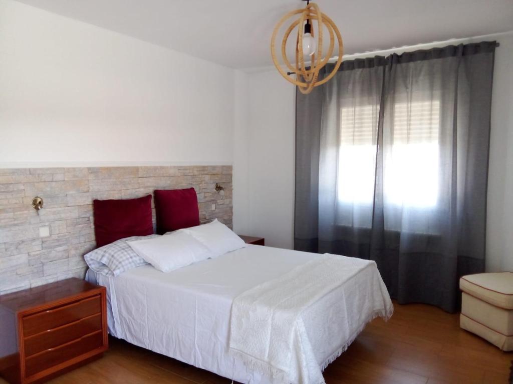 ein Schlafzimmer mit einem weißen Bett und einem Fenster in der Unterkunft La Casa de Marta in Chiloeches
