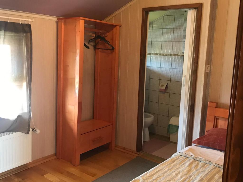 a bedroom with a bed and a bathroom with a shower at Pensiunea Iona in Baia Mare