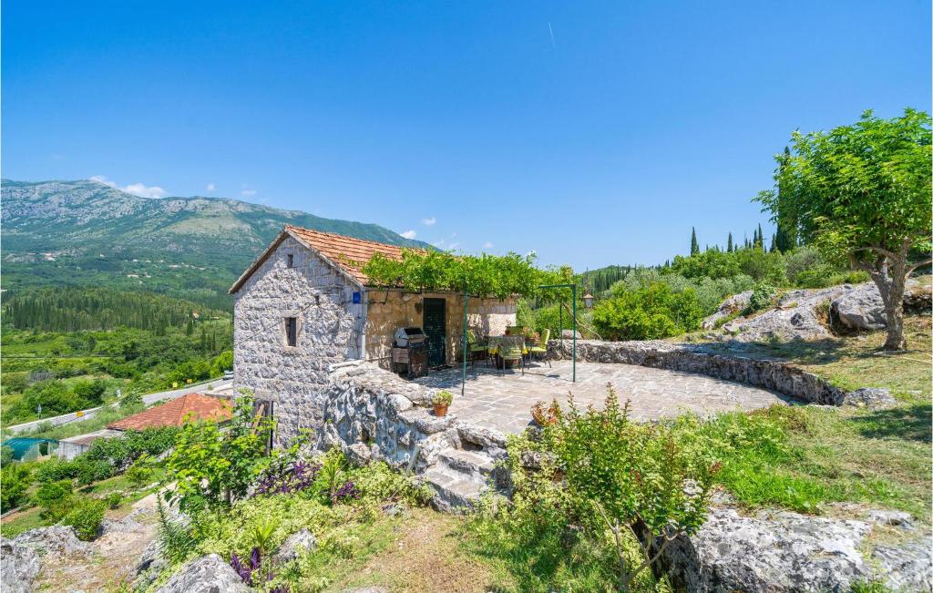 a small stone building on a hill with trees at Beautiful Home In Gruda With Wifi in Gruda