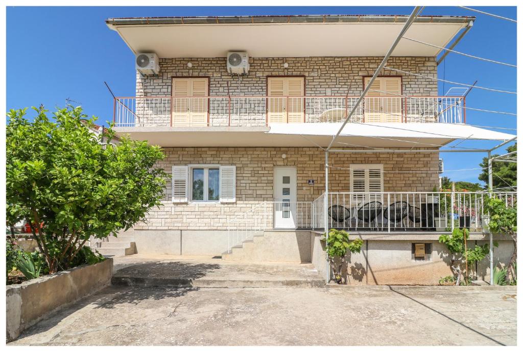 a house with a balcony on top of it at Apartment Ballin in Primošten