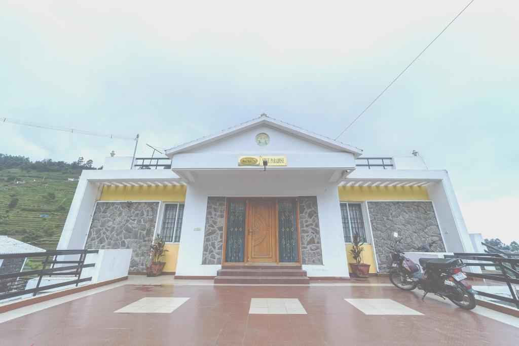 a building with a motorcycle parked in front of it at KBS Sree Paradise Kodai in Kodaikānāl
