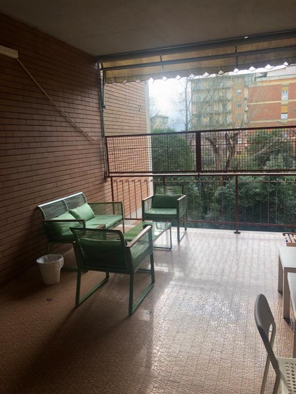 Pokój z 2 zielonymi krzesłami i dużym oknem w obiekcie Affittacamere Novoli we Florencji