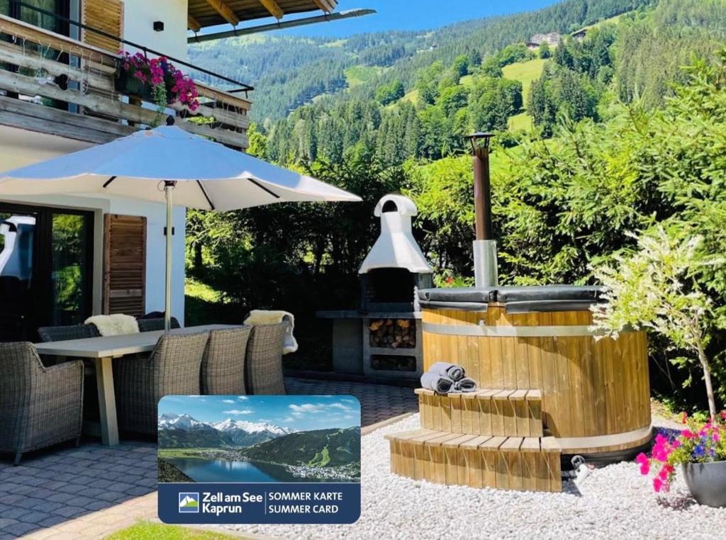 a patio with an outdoor grill and an umbrella at Chalet Zell by Chalet Alp Lux in Zell am See