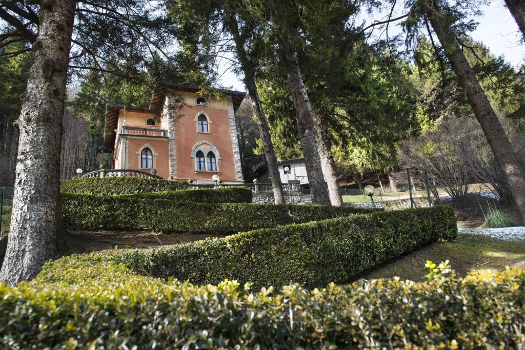 a house in a park with trees and bushes at Villa Pinetina B&B in Lasnigo