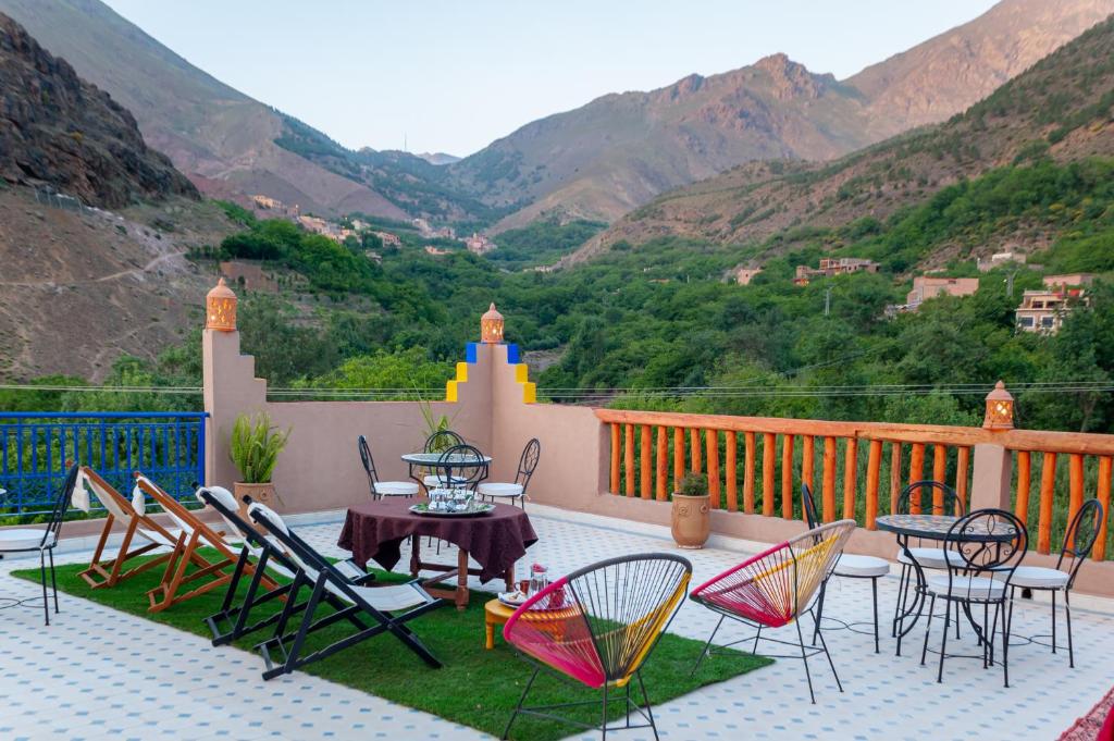 d'une terrasse avec des chaises et une table sur un balcon avec des montagnes. dans l'établissement Smile House Imlil, à Imlil