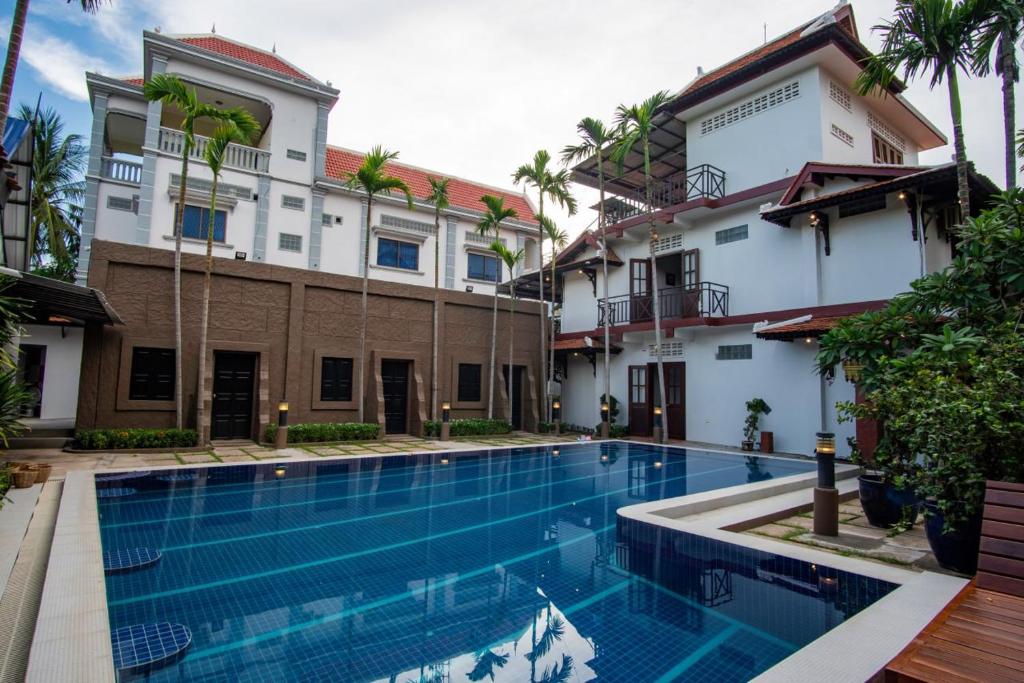a swimming pool in front of a building at NeakBong Residence in Siem Reap