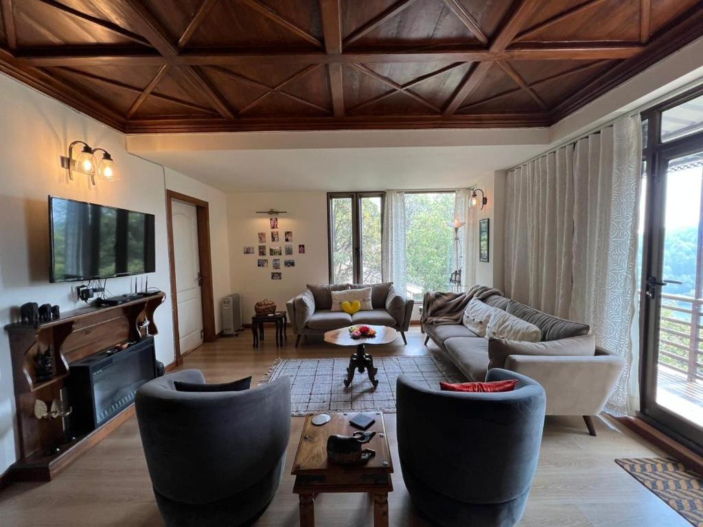 a large living room with couches and a tv at Villa Bliss Lakeside in Nainital