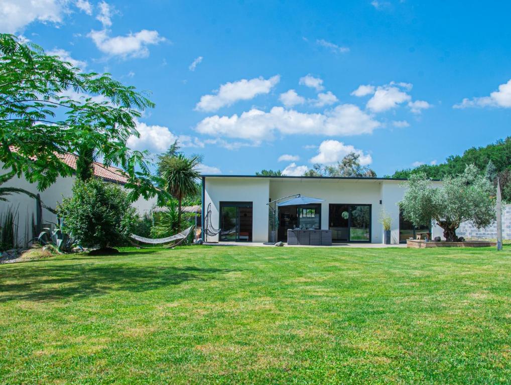 una casa con un prato davanti di La Villa Ô Bois - Billard & Baby-Foot - face à la forêt a Séméac