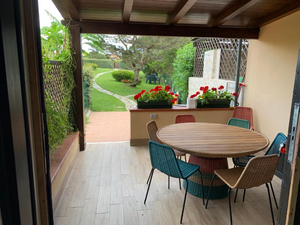 uma mesa e cadeiras num alpendre com uma mesa e um pátio em Pelosa - Capo Falcone Excellent Apartment em Stintino